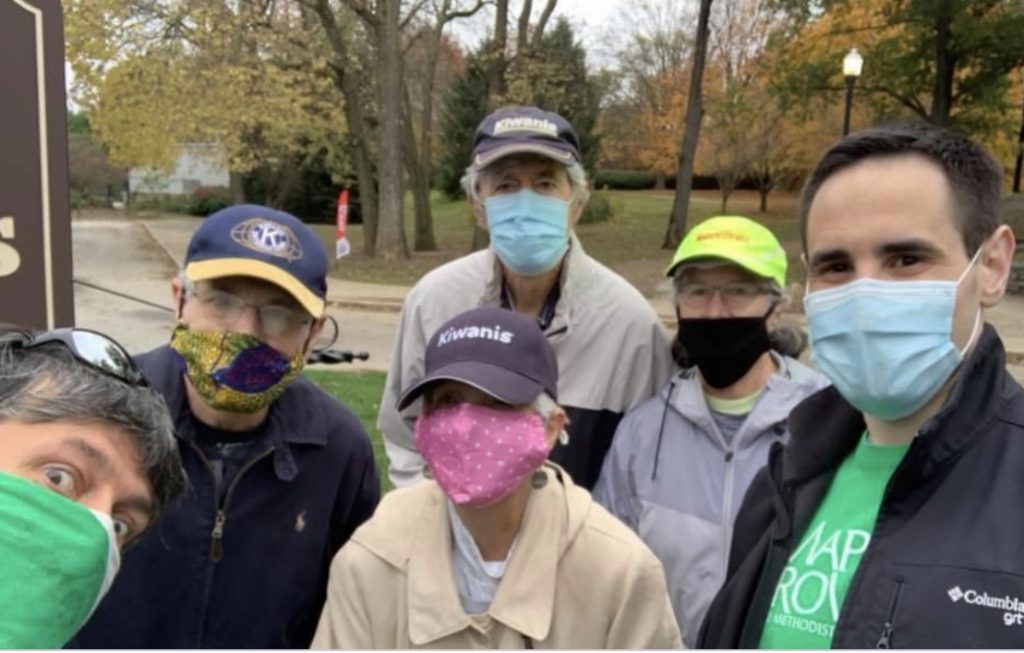 People wearing masks standing in a park
